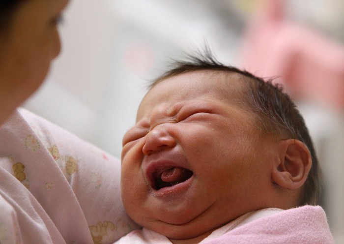 Một bé sơ sinh cất tiếng khóc chào đời trong vòng tay y tá ở bệnh viện ở Đài Bắc, Đài Loan.